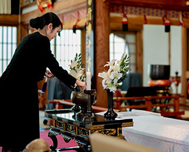 葬儀祭壇に向かって焼香をする女性